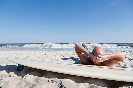simsearch:649-07437735,k - Surfer lying on surfboard on beach Photographie de stock - Premium Libres de Droits, Code: 614-09210031