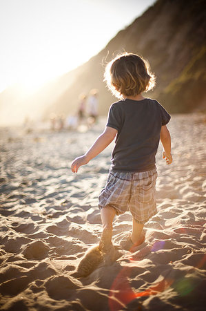 simsearch:614-08874062,k - Little boy on sandy beach at sunset Fotografie stock - Premium Royalty-Free, Codice: 614-09210072