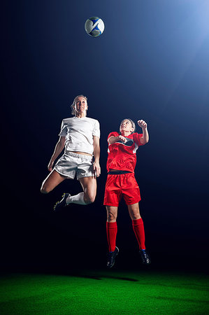 simsearch:614-07146416,k - Two female soccer players heading ball Foto de stock - Sin royalties Premium, Código: 614-09210342