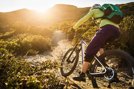 Young woman mountain biking on dirt track, Monterey, California, USA Stock Photo - Premium Royalty-Free, Code: 614-09210546