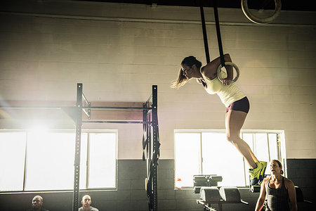 simsearch:632-06118219,k - Young woman on gymnasium rings watched by trainer Stock Photo - Premium Royalty-Free, Code: 614-09210748