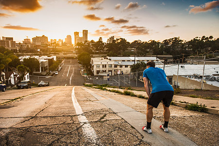 exhausted man on the road - Young male runner taking a break at the top of a steep city hill Stock Photo - Premium Royalty-Free, Code: 614-09211097