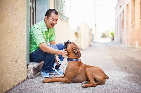 Mid adult man petting his boxer dog on doorstep Fotografie stock - Premium Royalty-Free, Codice: 614-09211171
