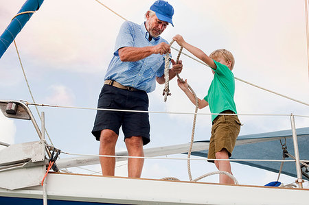 rope deck knot - Boy and grandfather knotting rope on sailboat Photographie de stock - Premium Libres de Droits, Code: 614-09211394