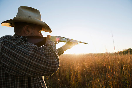 simsearch:614-08081431,k - Senior male farmer aiming shotgun in remote field at dusk, Plattsburg, Missouri, USA Stock Photo - Premium Royalty-Free, Code: 614-09211447