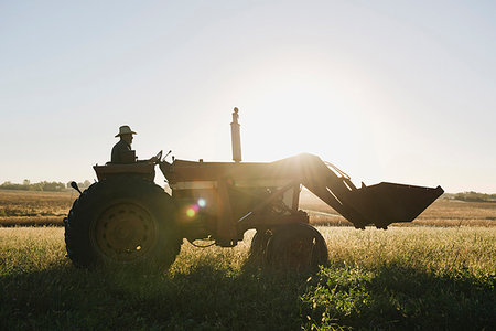 simsearch:614-08065938,k - Silhouetted senior male farmer driving tractor in field, Plattsburg, Missouri, USA Stock Photo - Premium Royalty-Free, Code: 614-09211451