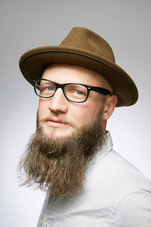 Studio portrait of mid adult man in trilby with overgrown beard Stock Photo - Premium Royalty-Free, Code: 614-09211508