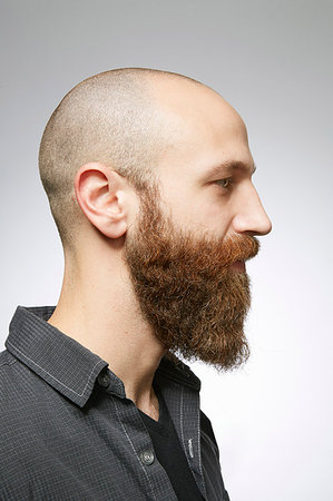 simsearch:614-07146362,k - Studio profile portrait of mid adult man with shaved hair and overgrown beard Fotografie stock - Premium Royalty-Free, Codice: 614-09211510