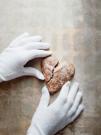 Gloved hands holding heart-shaped gingerbread cookie Stock Photo - Premium Royalty-Free, Code: 614-09211567