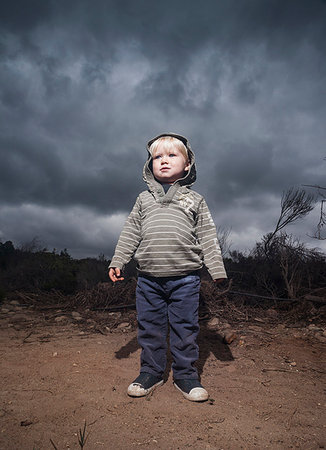 simsearch:614-08872791,k - Young boy standing against stormy sky Fotografie stock - Premium Royalty-Free, Codice: 614-09211609