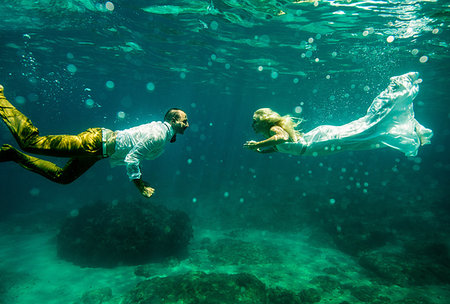 people in jamaica - Couple in wedding attire, underwater, swimming towards each other Stock Photo - Premium Royalty-Free, Code: 614-09211798