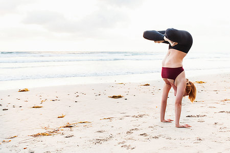 simsearch:614-07239925,k - Mid adult woman upside down in yoga position on beach Photographie de stock - Premium Libres de Droits, Code: 614-09211846