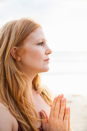 simsearch:649-07560073,k - Close up of mid adult woman practicing yoga with hands together on beach Stock Photo - Premium Royalty-Free, Code: 614-09211848