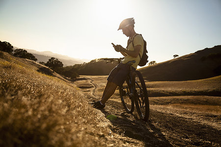 Silhouetted young male mountain biker using smartphone, Mount Diablo, Bay Area, California, USA Stock Photo - Premium Royalty-Free, Code: 614-09212095