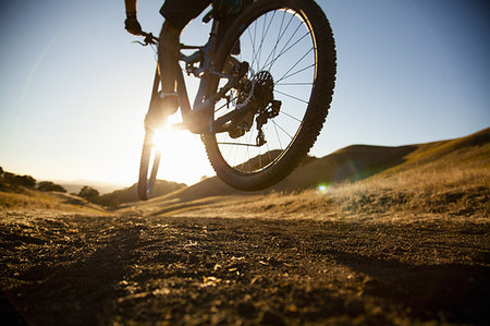 Silhouetted cropped view of young man mountain biking up dirt track, Mount Diablo, Bay Area, California, USA Stock Photo - Premium Royalty-Free, Code: 614-09212097