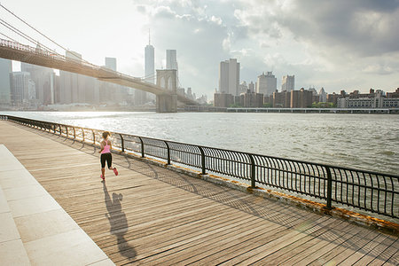 Young female runner running along riverside, Brooklyn, New York, USA Stock Photo - Premium Royalty-Free, Code: 614-09212119