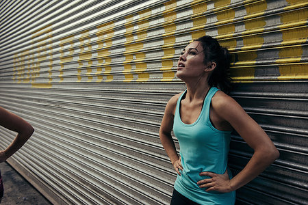 simsearch:614-07652365,k - Young woman taking a break from running, against shutter Foto de stock - Sin royalties Premium, Código: 614-09212123