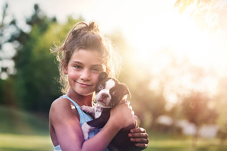 simsearch:614-09212260,k - Girl holding Boston Terrier puppy cheek to cheek looking at camera smiling Stock Photo - Premium Royalty-Free, Code: 614-09212165