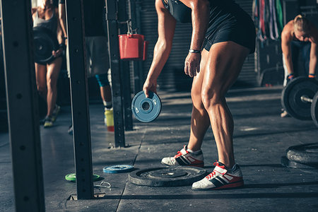 simsearch:614-08877139,k - Cropped view of crossfitters preparing weights for barbells  in gym Stock Photo - Premium Royalty-Free, Code: 614-09212218