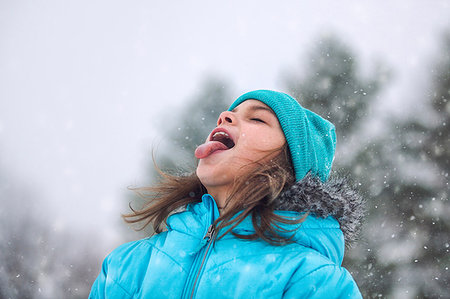 simsearch:614-09212275,k - Girl looking up, sticking out tongue catching snowflakes Photographie de stock - Premium Libres de Droits, Code: 614-09212266