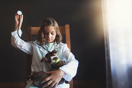 simsearch:614-09212260,k - Girl sitting on chair dressed up as doctor tending to Boston terrier puppy using stethoscope Stock Photo - Premium Royalty-Free, Code: 614-09212260