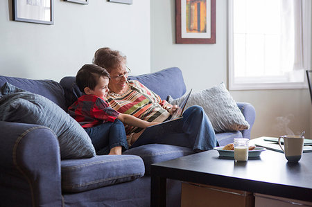 simsearch:6113-07906393,k - Senior woman reading book with grandson on sofa Stock Photo - Premium Royalty-Free, Code: 614-09212318