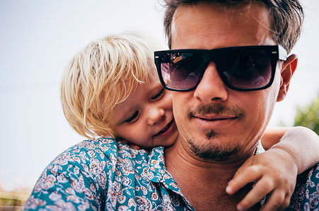 person in hawaiian shirt - Portrait of father with son, wearing sunglasses looking at camera smiling, Luino, Lombardy, Italy Stock Photo - Premium Royalty-Free, Code: 614-09212364