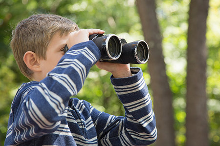 simsearch:614-08878862,k - Boy looking through binoculars in woods Fotografie stock - Premium Royalty-Free, Codice: 614-09212368