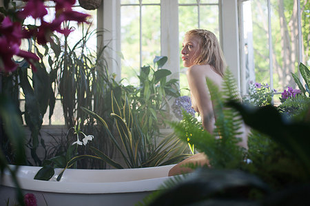 simsearch:649-08086724,k - Nude young woman sitting on edge of bathtub, in bathroom full of plants Stockbilder - Premium RF Lizenzfrei, Bildnummer: 614-09212412