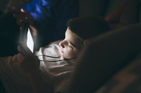 simsearch:614-02004637,k - High angle view of boy on sofa wearing earphones using digital tablet Photographie de stock - Premium Libres de Droits, Code: 614-09212424