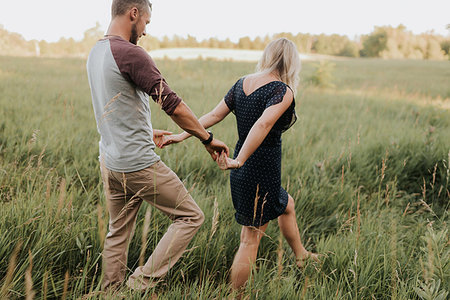 paseando - Romantic man and girlfriend strolling in field of sunlit long grass Foto de stock - Sin royalties Premium, Código: 614-09213916
