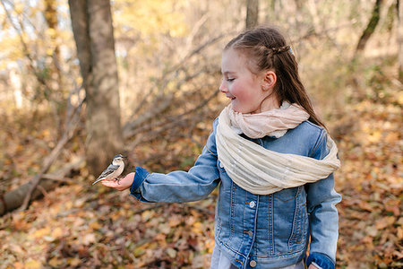 Little girl holding bird on palm in forest Stock Photo - Premium Royalty-Free, Code: 614-09231981