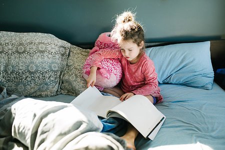 Little girl reading in bed Stock Photo - Premium Royalty-Free, Code: 614-09232076