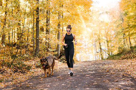 distant forest people - Woman jogging with dog in forest Stock Photo - Premium Royalty-Free, Code: 614-09232080