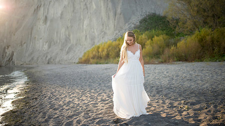 Bride in wedding dress on beach at sunset, Scarborough Bluffs, Toronto, Canada Stock Photo - Premium Royalty-Free, Code: 614-09232217