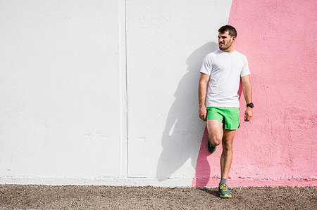 shoes wearing man - Young male runner leaning against pink and white wall Stock Photo - Premium Royalty-Free, Code: 614-09245236