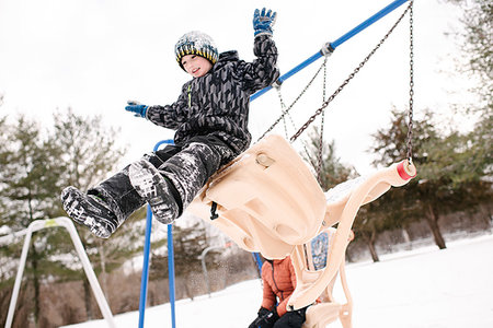 simsearch:649-08902297,k - Boy jumping from playground swing in snow Photographie de stock - Premium Libres de Droits, Code: 614-09245244