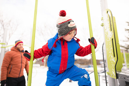 simsearch:614-09245239,k - Boy with father climbing up playground slide in snow Foto de stock - Sin royalties Premium, Código: 614-09245242