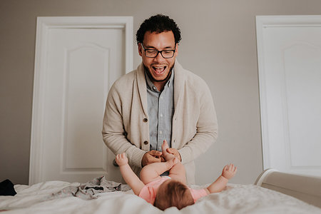 simsearch:614-08881045,k - Father dressing baby daughter on bed in bedroom Fotografie stock - Premium Royalty-Free, Codice: 614-09249535