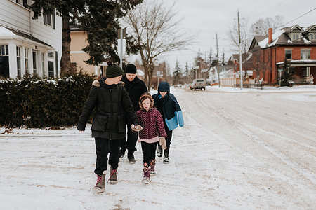 Parents and children walking on snow covered street Stock Photo - Premium Royalty-Free, Code: 614-09249585