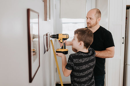 drilling wall - Father teaching son drill wall for picture frames Stock Photo - Premium Royalty-Free, Code: 614-09249607