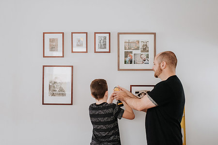 drilling wall - Father teaching son drill wall for picture frames Stock Photo - Premium Royalty-Free, Code: 614-09249609