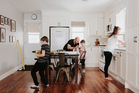 Family of four busy with chores in kitchen Stock Photo - Premium Royalty-Free, Code: 614-09249614