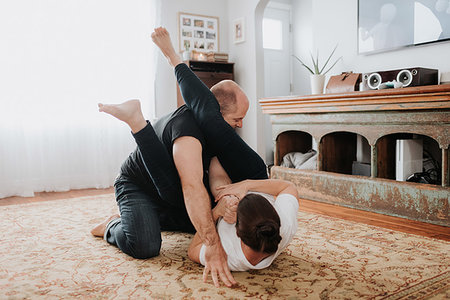 Couple wrestling on carpet at home Stock Photo - Premium Royalty-Free, Code: 614-09249637