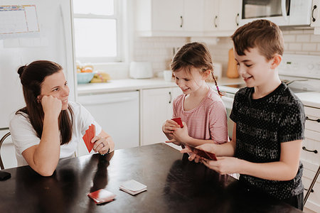 simsearch:614-08641537,k - Mother and children playing cards in kitchen Photographie de stock - Premium Libres de Droits, Code: 614-09249631