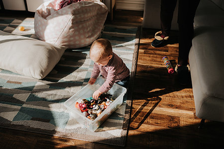 Baby boy sitting on living room floor playing with toys Photographie de stock - Premium Libres de Droits, Code: 614-09249648