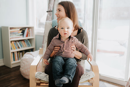 simsearch:614-09249646,k - Baby boy sitting on mother's lap in living room, portrait Fotografie stock - Premium Royalty-Free, Codice: 614-09249653