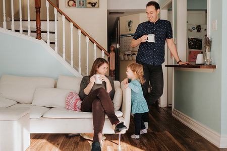 simsearch:614-09270476,k - Mid adult couple having mug of coffee in living room with toddler daughter Stock Photo - Premium Royalty-Free, Code: 614-09249690