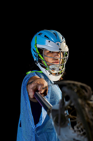 Young male lacrosse player lunging with lacrosse stick, portrait against black background Photographie de stock - Premium Libres de Droits, Code: 614-09249740