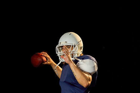 simsearch:6122-07698066,k - Portrait of quarterback with football, black background Stockbilder - Premium RF Lizenzfrei, Bildnummer: 614-09249761